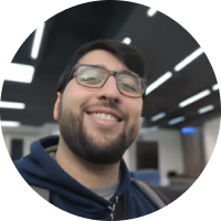 Juan F sonriente, Desarrollador FullStack e Ingeniero en Sistemas, en el trabajo.